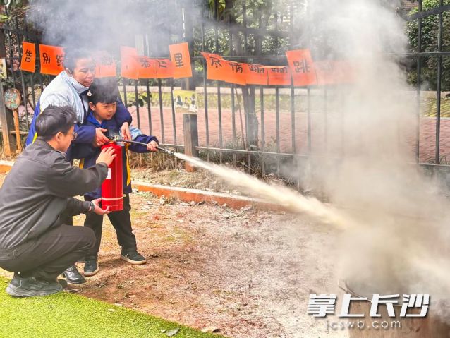 老师和小朋友在教官指导下体验使用灭火器灭火的过程，掌握了正确的灭火方法。  均为长沙晚报通讯员 孙岩岩供图