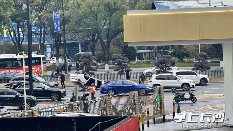 18日清晨7时38分，一辆白色轿车在城发能源四方城加油站旁发生侧翻。均为长沙晚报通讯员 唐盈盈 供图