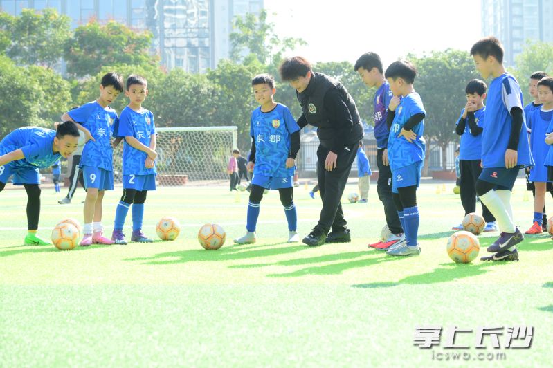 “湘超”联赛新星、该校校友马子宜教学弟们踢足球。