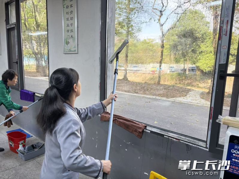 参加保洁员竞赛的选手擦拭玻璃。