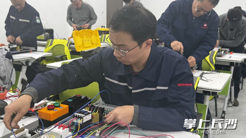 参加电工竞赛的选手进行电动机电动与长动控制线路接线。