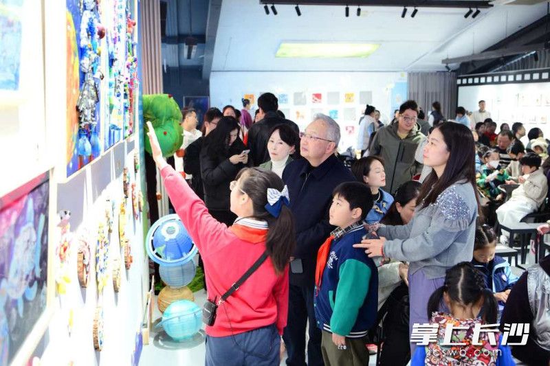 小志愿者向参观者介绍同学们的作品。照片由学校提供