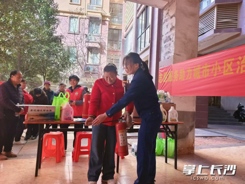 “屋场会”上，消防宣讲员手把手教居民灭火。 均为长沙晚报通讯员方圆摄