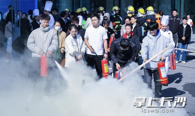 学员在教官指导下亲手操作灭火器。