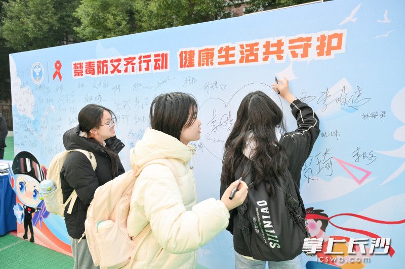 参加活动的高校学子纷纷在主题签名墙上签名承诺。 均为长沙晚报通讯员刘军民摄
