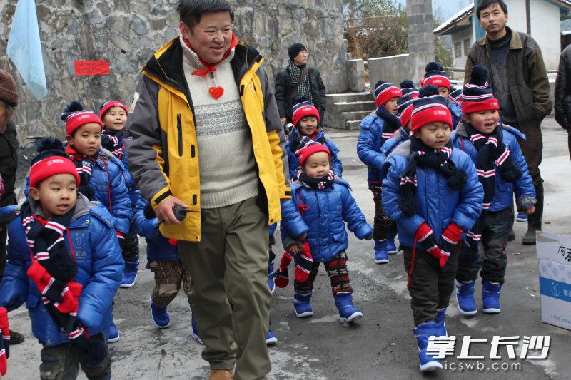 傅强(中)为湘西地区贫困孩子送去冬衣。 均为受访者供图 傅强(中)为湘西地区贫困孩子送去冬衣。 均为受访者供图
