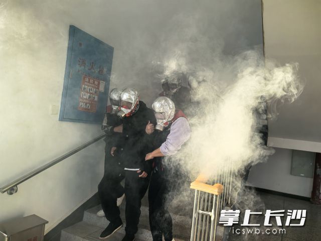 实战演练环节，行动不便的老人由工作人员搀扶“撤离”。  