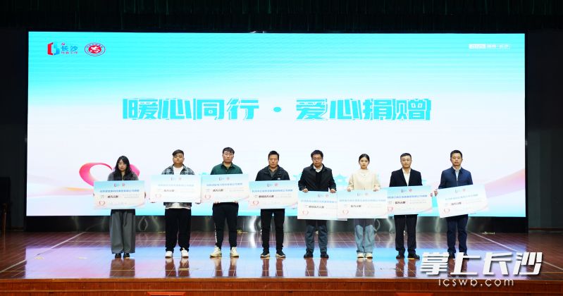 8家爱心企业代表上台为长沙市志愿服务和社会工作发展基金捐款。