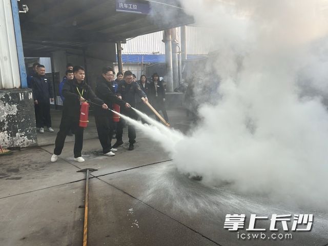 参训人员轮流上阵，体验灭火器的规范操作。