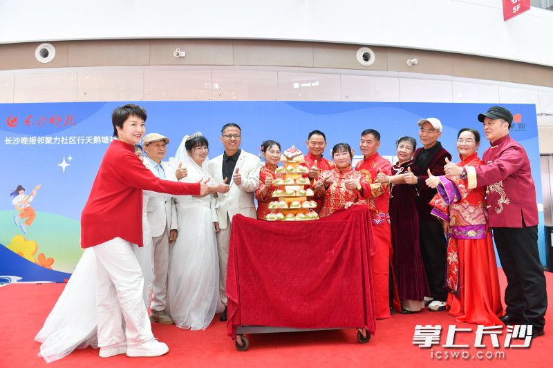 岳麓区人大代表、长沙市工商联执委、湖南家有爱食品有限公司董事长何蓉为参加“金银婚典礼”的长者们送上寿桃。 均为长沙晚报全媒体记者王志伟摄