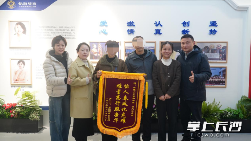 罗先生和骆女士将一面绣有“怡人春风化危难 雅量高行照杏华”14个大字的锦旗送给学校和两位老师。通讯员李静 供图 罗先生和骆女士将一面绣有“怡人春风化危难 雅量高行照杏华”14个大字的锦旗送给学校和两位老师。通讯员李静 供图