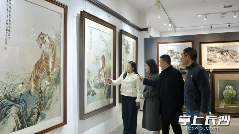 江再红（左一）在长沙市湘绣研究所内向参观者介绍其湘绣代表作。 长沙晚报全媒体记者 刘琼萍 聂思佳 摄