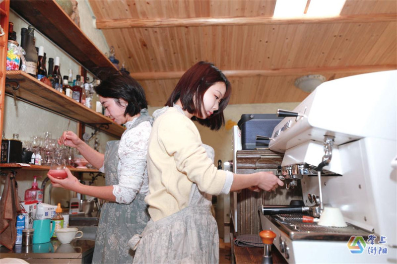 李娜(左)与李灿(右)在吧台内调配饮品、制作咖啡。 李娜(左)与李灿(右)在吧台内调配饮品、制作咖啡。