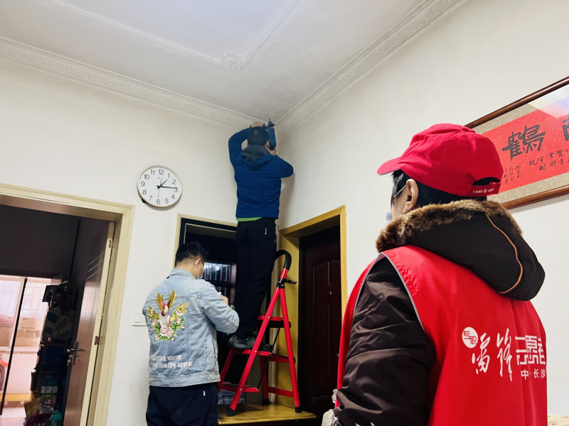 社区工作人员到独居老人家检修智能烟感报警系统。 均为长沙晚报全媒体记者 李卓 通讯员 罗孟 摄影报道