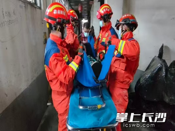 消防人员合力救助患病老人。 长沙晚报通讯员 刘伟 摄