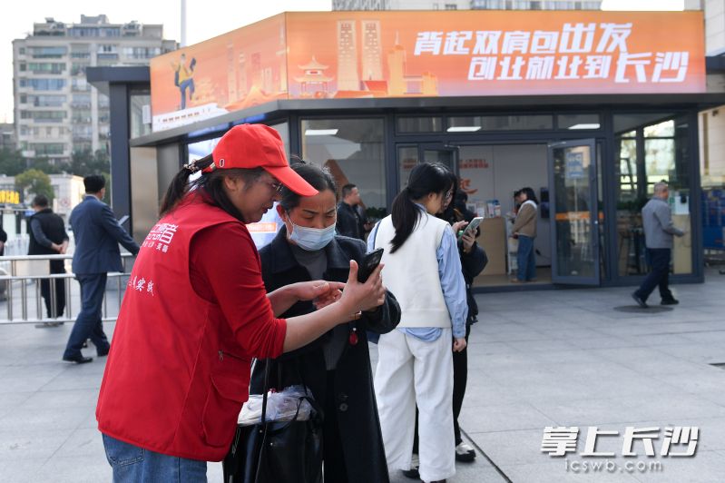志愿者正在为旅客提供服务。 志愿者正在为旅客提供服务。
