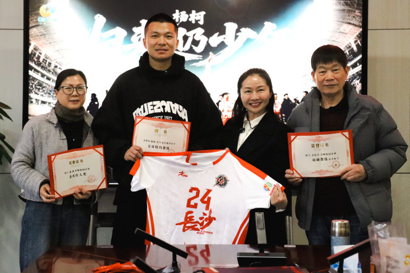 学校党总支书记肖陈慧为杨柯颁发“校园足球特约教练”聘书。