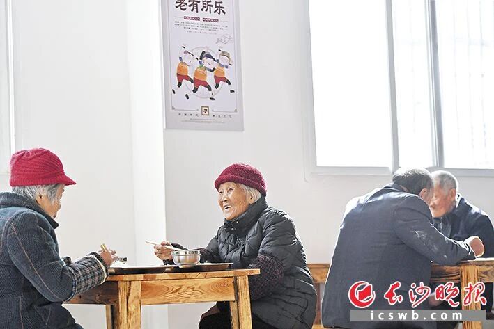 小河乡潭湾村的老年食堂里，老人们安心吃着午餐。王志伟 摄