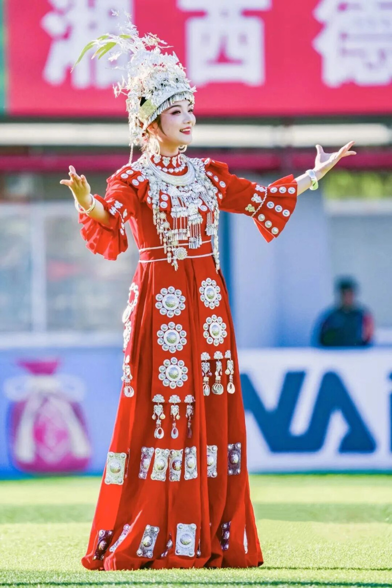 11月29日，本赛季“湘超”湘西队最后一个凤凰主场比赛前的文艺表演中，歌手身着苗族盛装献唱。胡承鼎 摄 图源：团结报