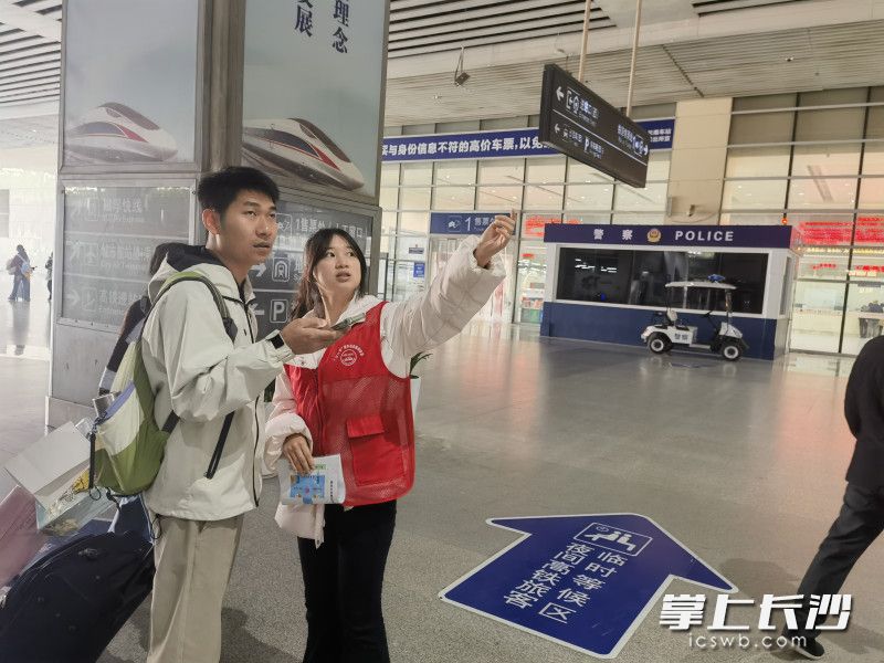 志愿者为旅客指路。 长沙晚报通讯员 侯文艳 摄