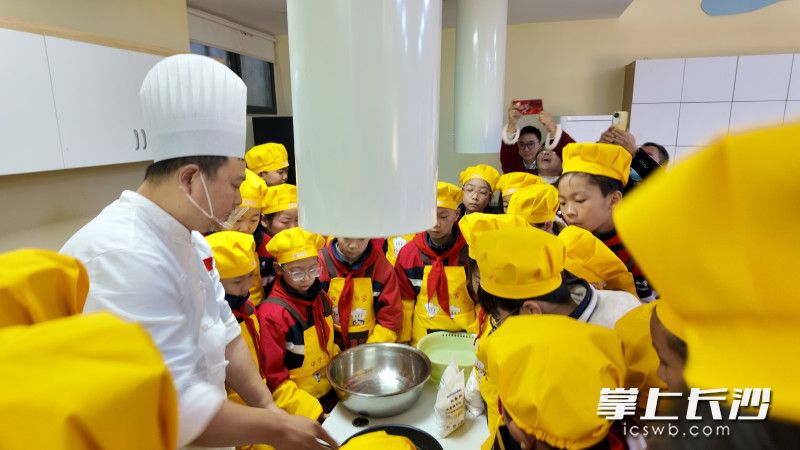 “教联体”项目展示活动上，来自火宫殿的大师傅教孩子们做糖油粑粑。