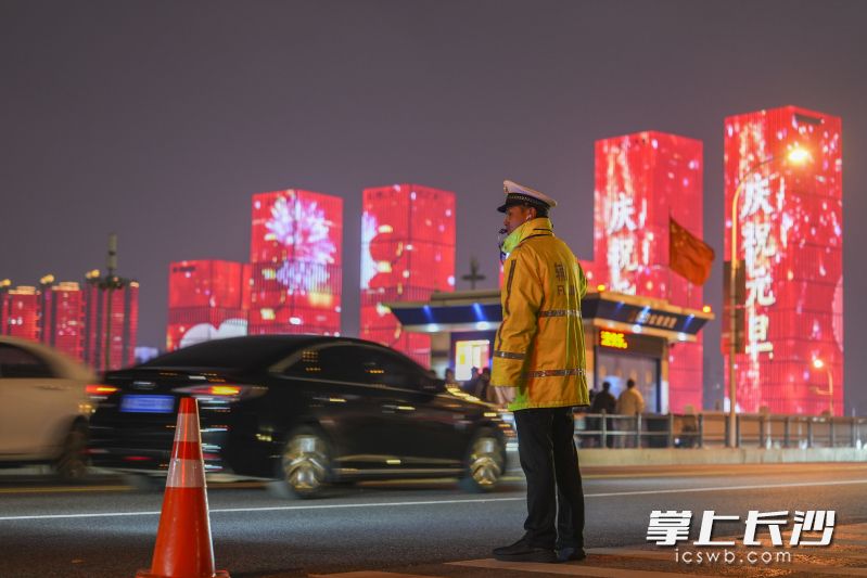 1月2日晚8时32分，在橘子洲大桥桥面，长沙市公安局交通警察支队岳麓大队民警在寒风中疏导交通。 均为长沙晚报全媒体记者郭雨滴，通讯员孙勇、彭滔摄