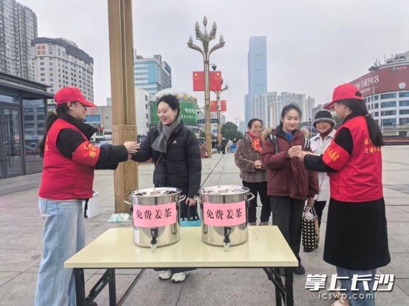 “红火炬”雷锋志愿者为旅客递上姜茶。