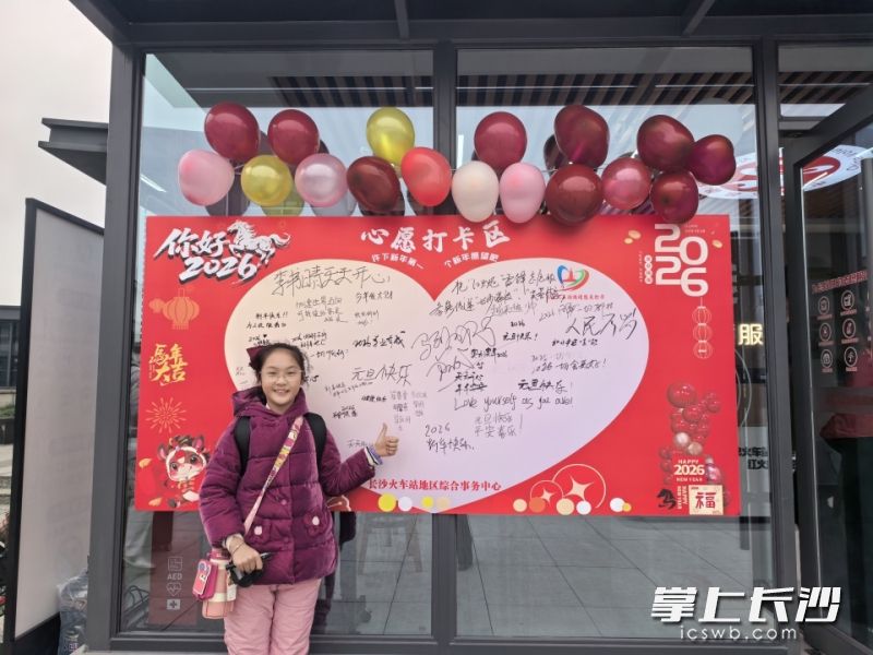 在长沙火车站“红火炬” 雷锋志愿服务站，旅客与新年心愿墙合影。均为通讯员供图