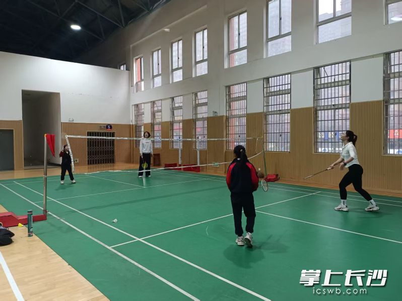 家长和孩子一起打羽毛球。