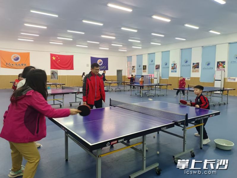 家长和孩子打乒乓球，既锻炼身体，也增进了亲子感情。