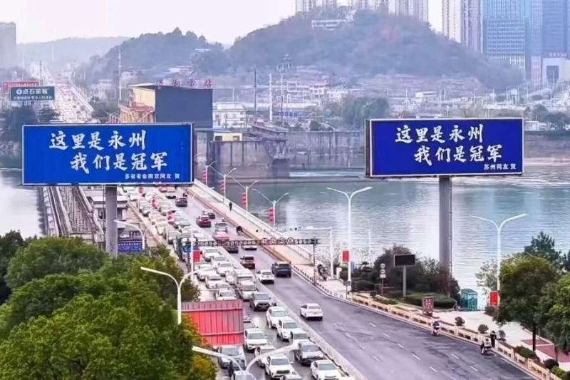 由苏州和南京网友各自买下的两个广告牌伫立在宋家洲大桥桥头。图源：永州融媒