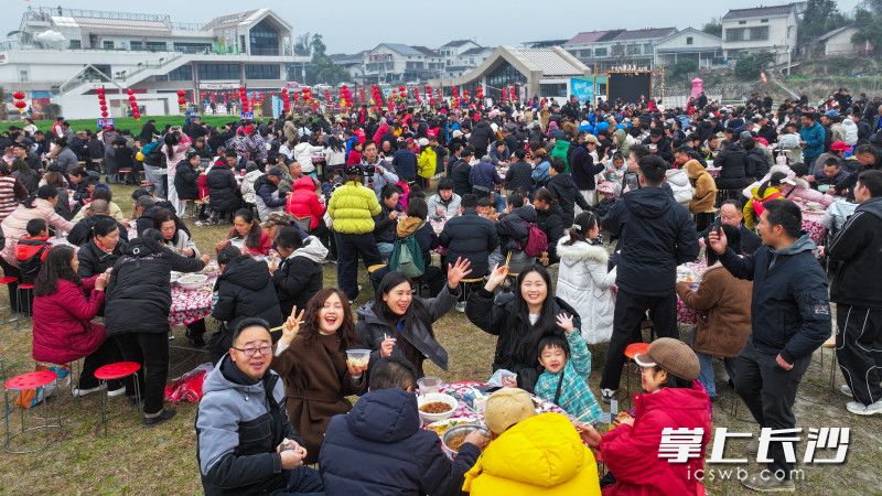 游客们围坐一堂，共享热气腾腾的杀猪宴,感受满满的年味。均为长沙晚报全媒体记者 邹麟 周数邑 摄