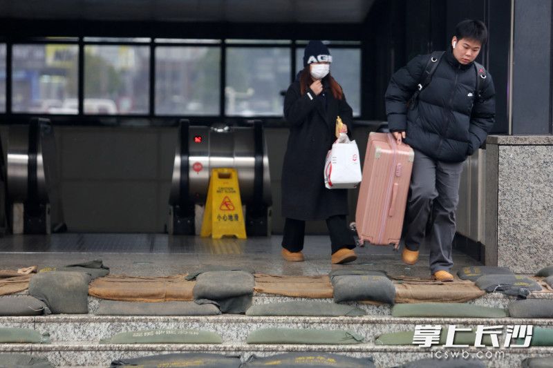 火车站广场地铁出入口铺上了防滑的麻袋和沙包。 均为长沙晚报全媒体记者贺文兵摄