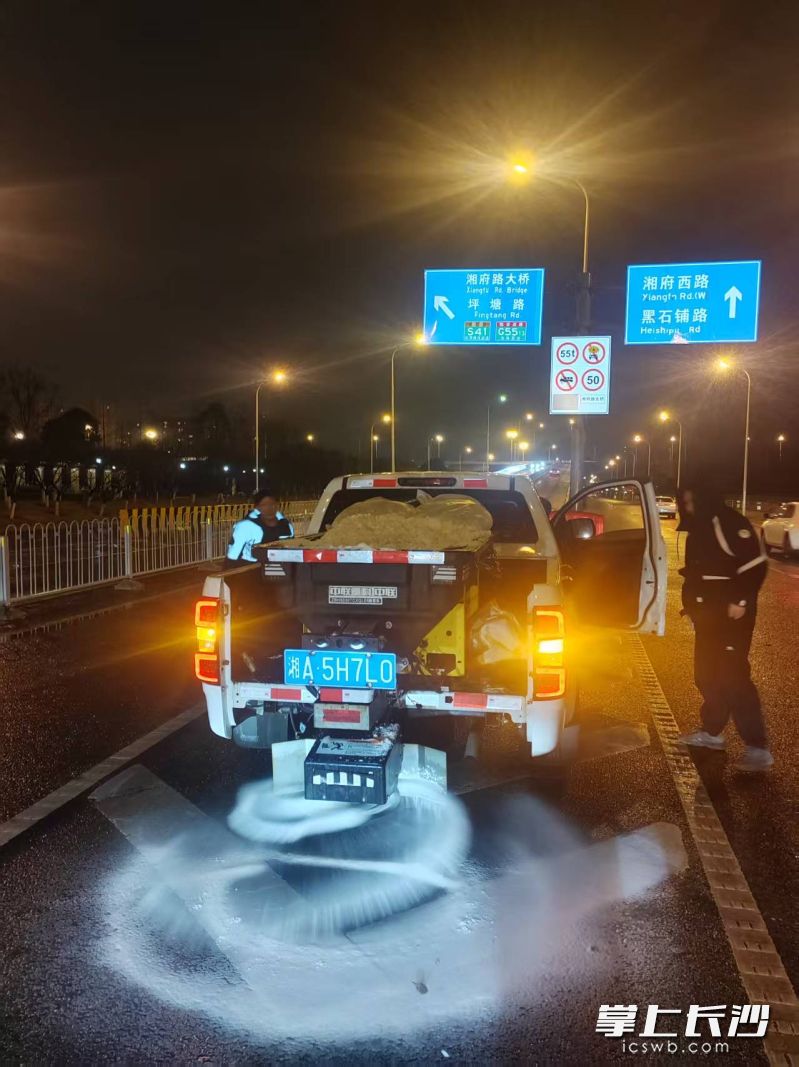 人车配合，在湘府路大桥路面撒盐。