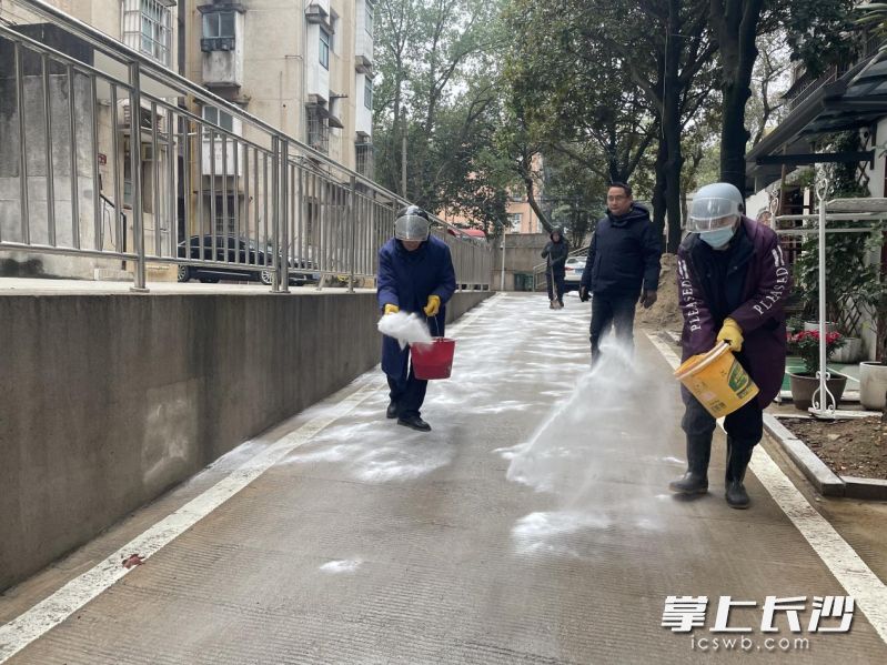 东湖街道东沙社区工作人员在小区内撒盐除冰。