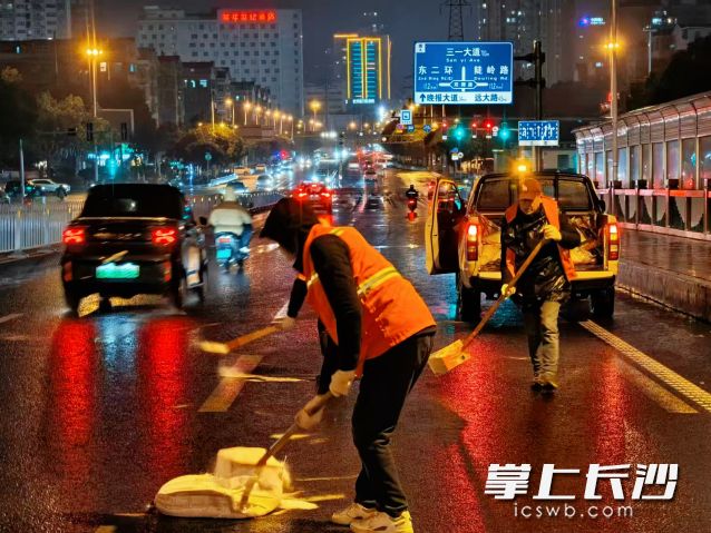 19日晚，工作人员正在进行撒盐工作。