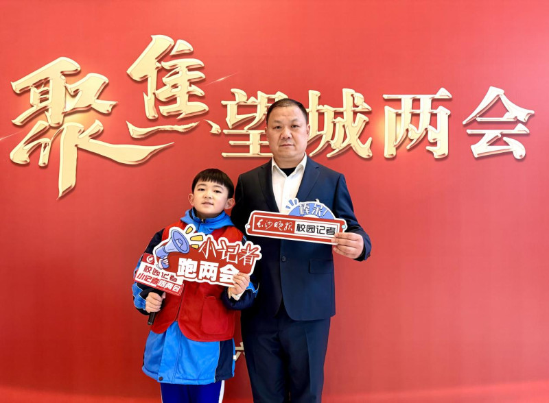 湖南师大附中星城实验第二小学2201班王也（“雷小锋”编号：086053）与望城区铜官片区党总支书记、校长文虎合影