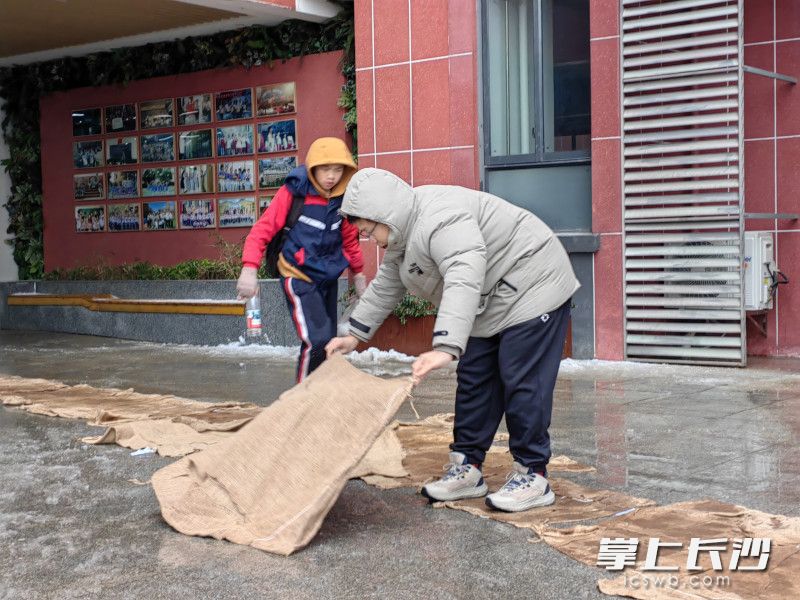 中午放学十分，孩子们安心地走在防滑麻袋铺设的“安全路”上。