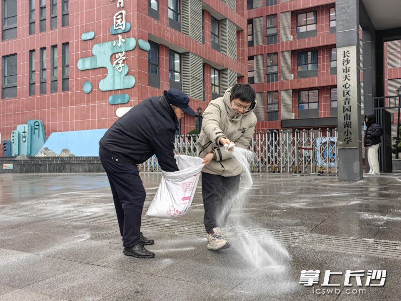 下午，学校后勤人员继续沿着学生放学的必经之路仔细补撒盐粒，防止路面结冰。