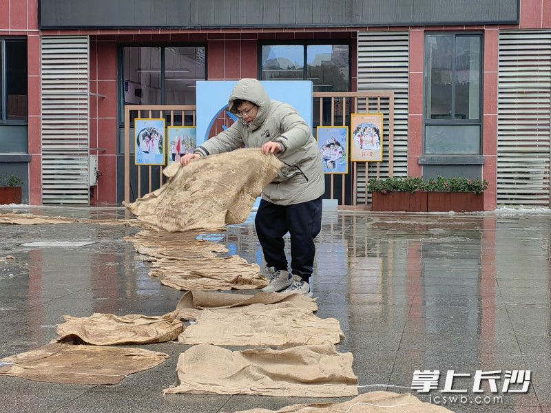 老师们在学生必经之路上铺设防滑麻袋。