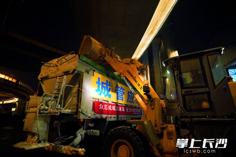 现场各种吨位的除冰撒布车正在装载除冰剂。