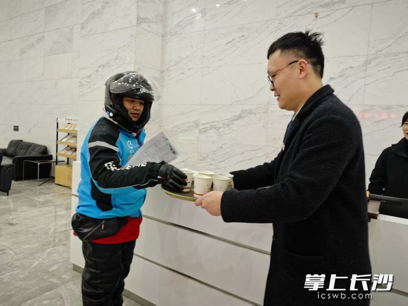在中盈广场写字楼大堂，豪布斯卡物业工作人员给快递小哥送上暖心姜茶。