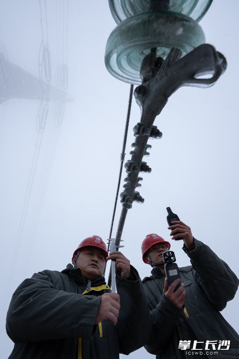 输电运检人员张丰(左)、蒋正湘对220千伏浏集Ⅰ线34号杆塔开展覆冰情况监测。 输电运检人员张丰(左)、蒋正湘对220千伏浏集Ⅰ线34号杆塔开展覆冰情况监测。