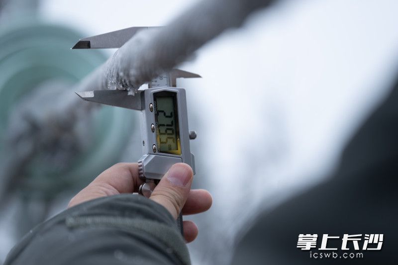 输电运检人员用游标卡尺测量模拟电线上的覆冰厚度。 输电运检人员用游标卡尺测量模拟电线上的覆冰厚度。
