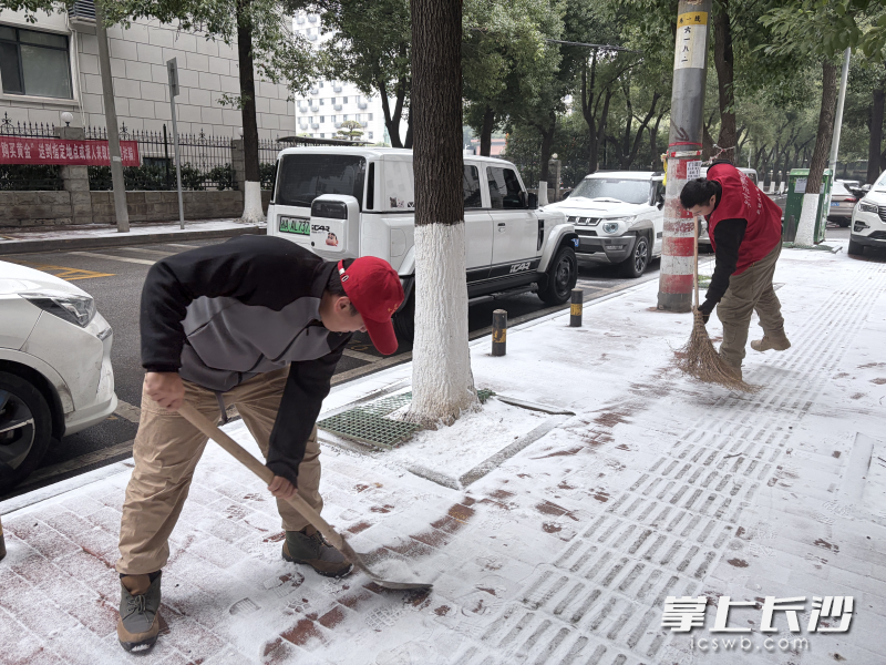 荷花园社区工作人员和志愿者在铲除路面积雪。