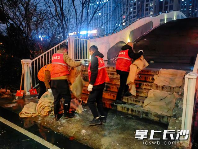 工作人员在易结冰点位铺上麻袋。 工作人员在易结冰点位铺上麻袋。