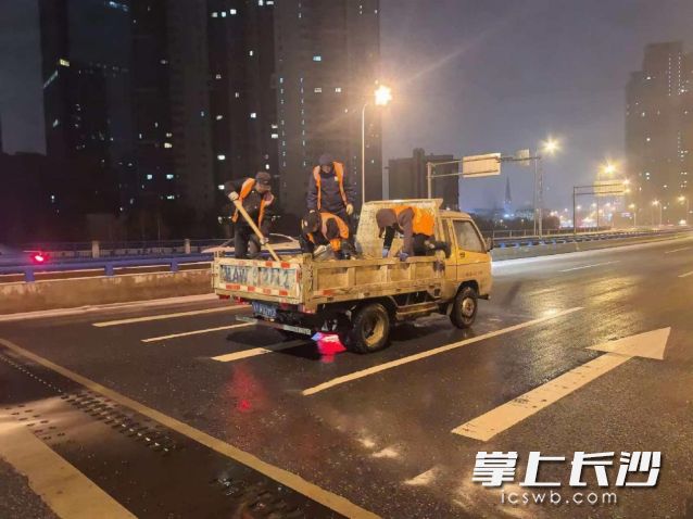 工作人员正在进行撒盐除冰作业。