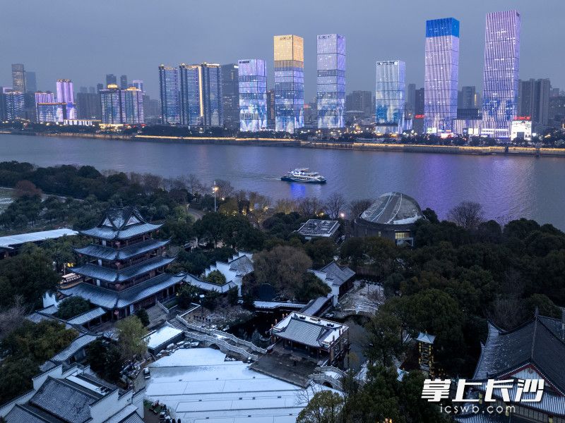 两岸的灯火一盏盏亮起，把每一片雪花点亮。