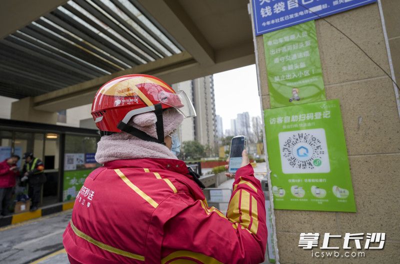 骑手扫码，系统即可自动核验其身份与实时订单信息，门禁自动放行。 全媒体记者 陈飞 摄