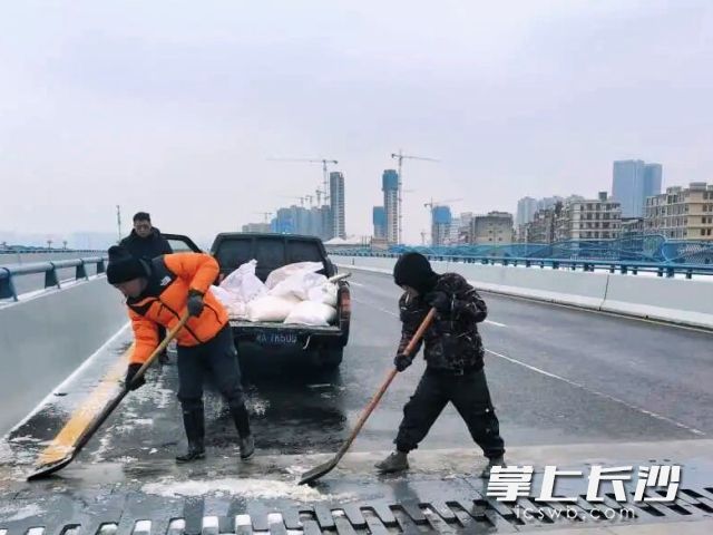 工作人员在铲冰扫雪。  均为长沙晚报通讯员 刘宇航 供图